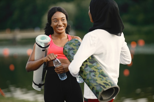 운동을 한 후 호수 근처에서 이야기하는 두 여성