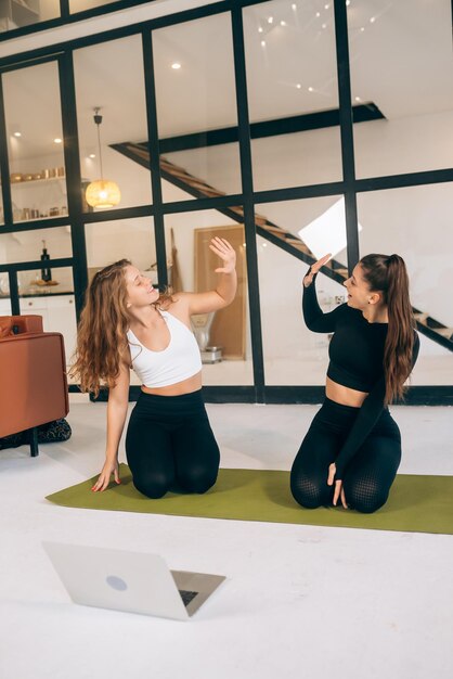 Two women while sitting in the lotus position give a high five