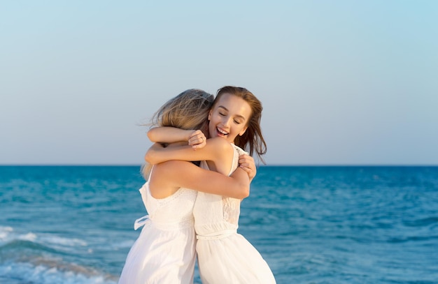 Two women in a white dress on beach