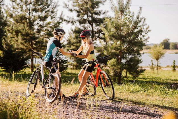 Two women with bikes stopped and have conversation outdoors in the park