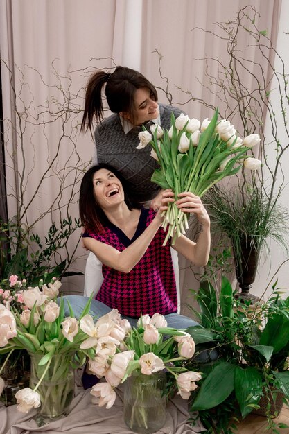 春の花のチューリップを持つ2人の女性