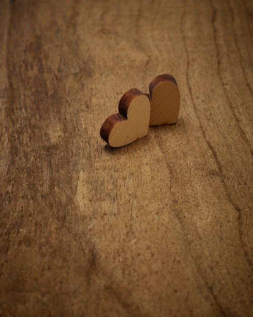 Two wood heart on wooden floor, top view