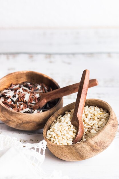 Two wooden bowls one with wild rice with brown rice