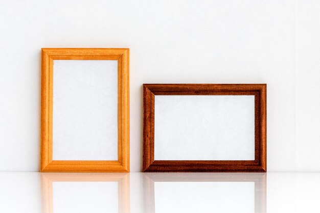 Two wooden frames with a white insert inside for text or drawing Photo frame on a white wall background