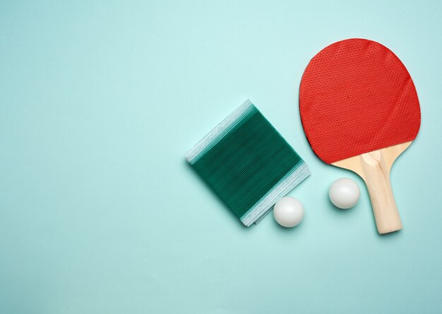 Photo two wooden rackets and an orange plastic ball for playing table tennis