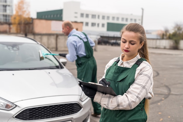 Two workers on car service posing near car