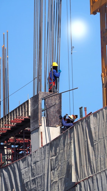 Two workers on the construction site with steel metal and cement and sun light.