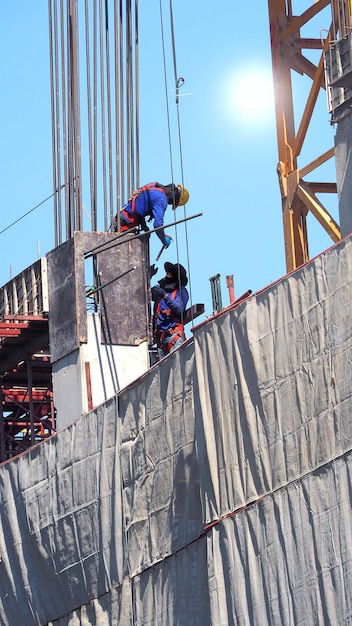 Two workers on the construction site with steel metal and cement and sun light.