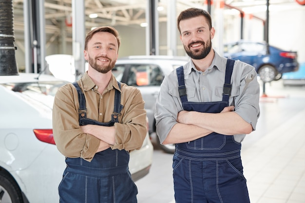 車のサービスでポーズをとる2人の労働者