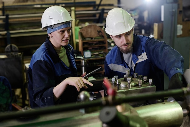 Two workers using industrial equipment