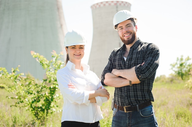 Two workers wearing protective helmet works at electrical power station