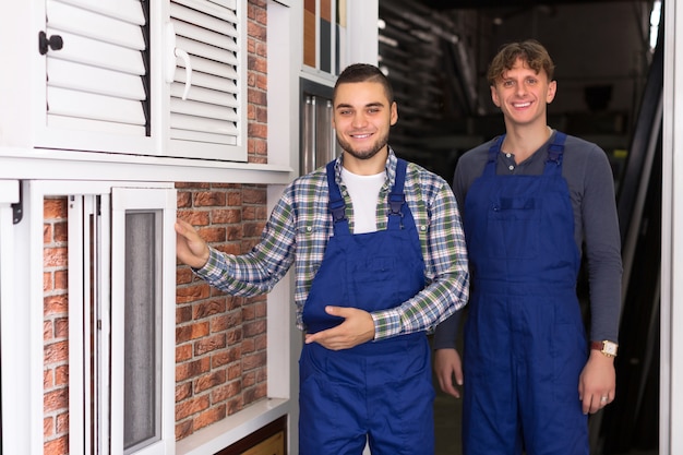 Two workmen inspecting windows