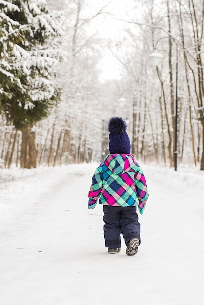 Двухлетняя девочка впервые наслаждается снегом.