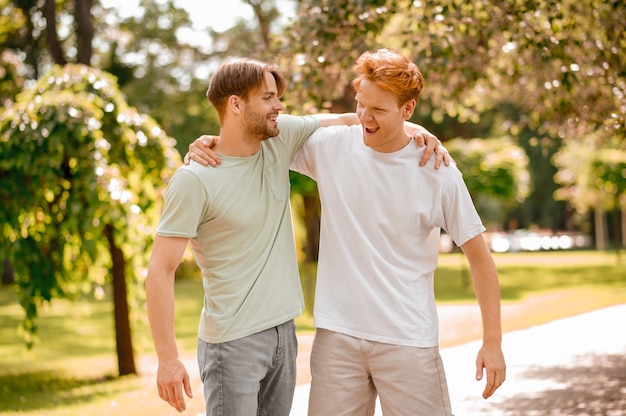 Two young adult guys rejoicing in meeting