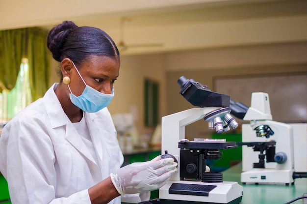 사회에서 발병의 치료에 대해 생명 과학 실험실에서 일하는 두 젊은 아프리카 건강 관리 연구원.