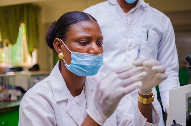 Foto due giovani ricercatori sanitari africani che lavorano nel laboratorio di scienze della vita sulla cura dell'epidemia nella società.