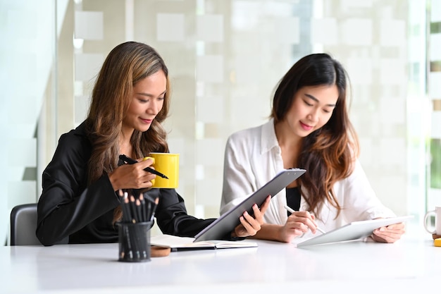 Two young asian businesswoman working together in modern office