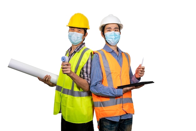 Foto due giovani ingegneri asiatici che indossano maschera chirurgica con tablet e progetto isolato su sfondo bianco nuovo concetto normale con tracciato di ritaglio