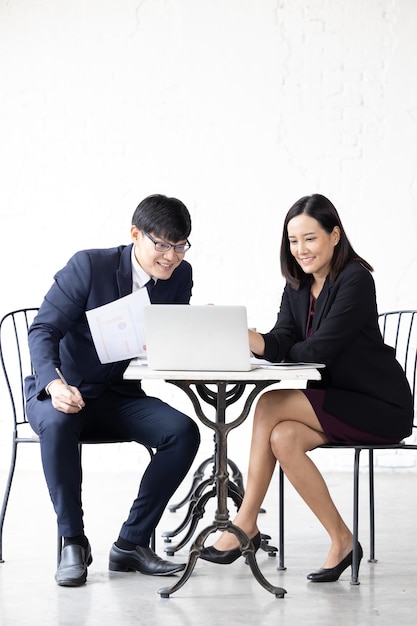 Two young Asian woman and man working with computer laptop Young asian startup small business man and woman happy using laptop Asian Businessman and Businesswoman