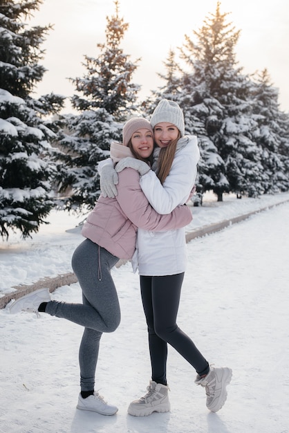 Two young athletic girls walking and playing sports on a sunny winter day. A healthy way of life.