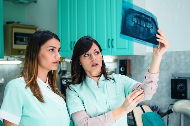 Two young beautiful dentists working together