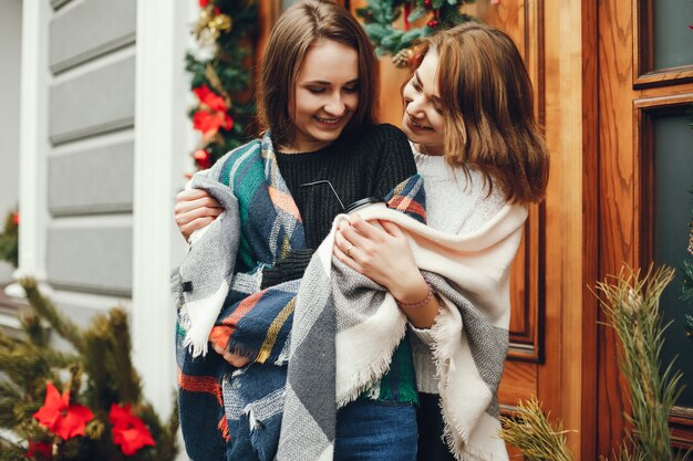 two young and beautiful girls standing in a spring city 