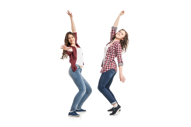 Two young beautiful happiness women dancing over white background