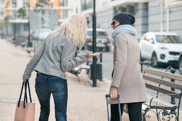 Two young beautiful women in warm clothes walking