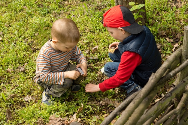 Two young boys lighting a small fire