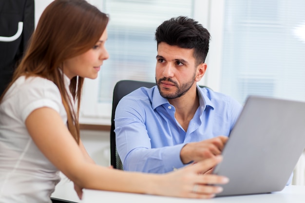 Two young business partners discussing plans or ideas at meeting