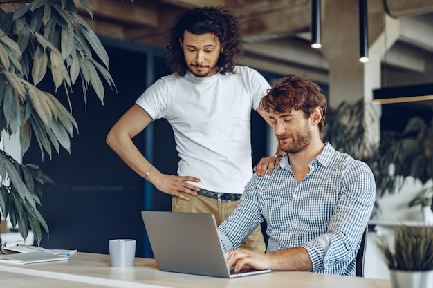 Two young businessmen discussing some ideas in modern office