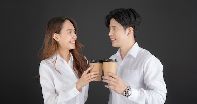 Two young businessmen standing and drinking coffee