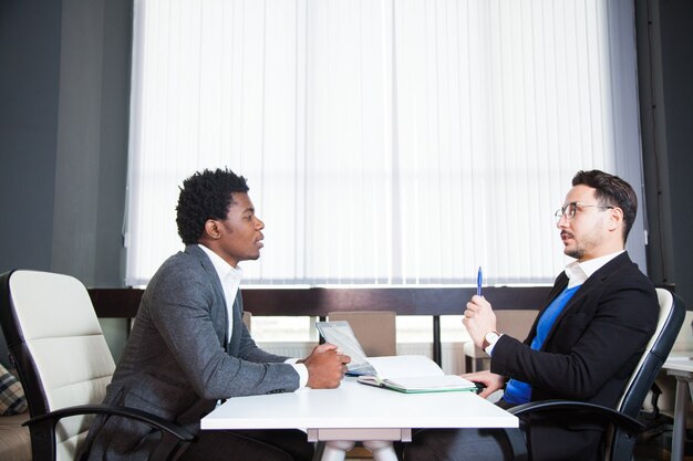 Two young businessmen, white desk