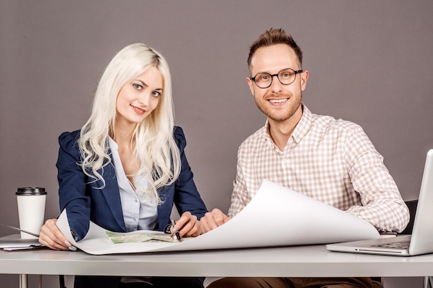 Two Young Businesspeople At Desk In Office