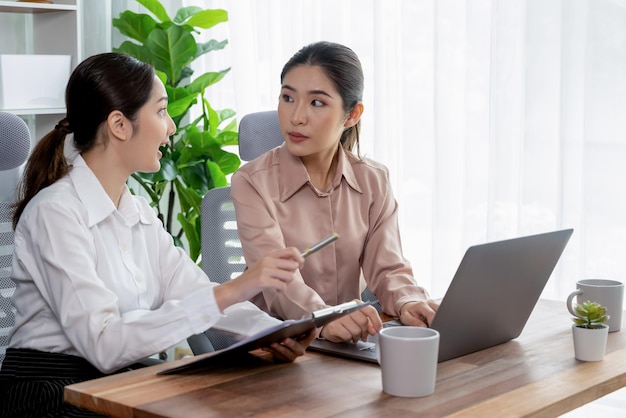 Two young businesswoman work together in office workspace Enthusiastic