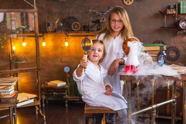 Two young children conduct interesting chemical experiments with smoke at school. Education