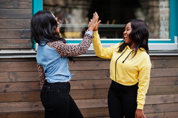 Photo two young college african american woman friends give high five each other.