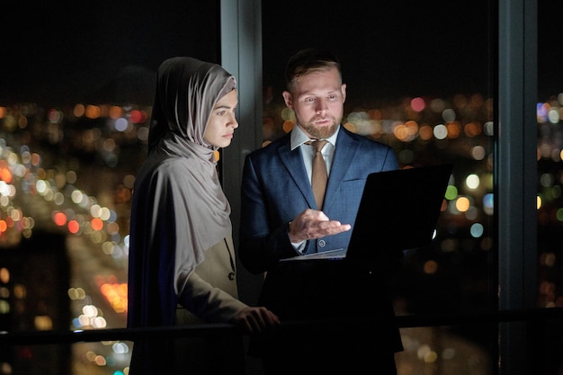 Two young confident colleagues preparing presentation