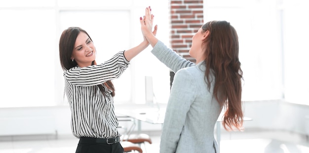 Two young coworkers giving each other a high five