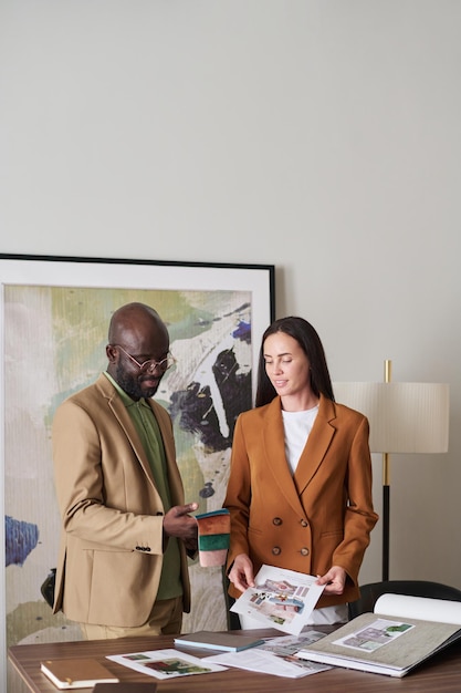 Two young creative designers of interior looking through collection of samples