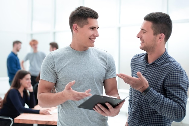 Two young employees discussing a business document