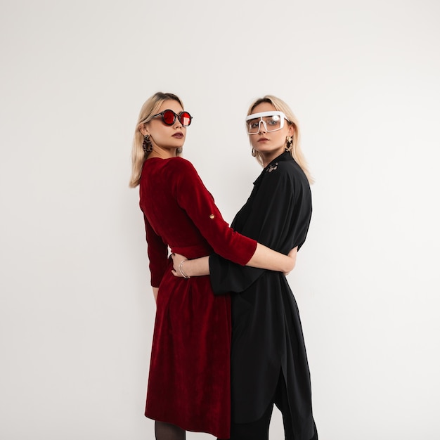 Two young fashionable girlfriends girls with cool sunglasses in stylish trendy clothes posing