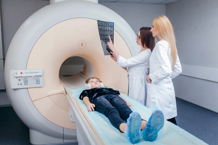 MRI 방에서 아이를 검사하는 두 젊은 여성 의사