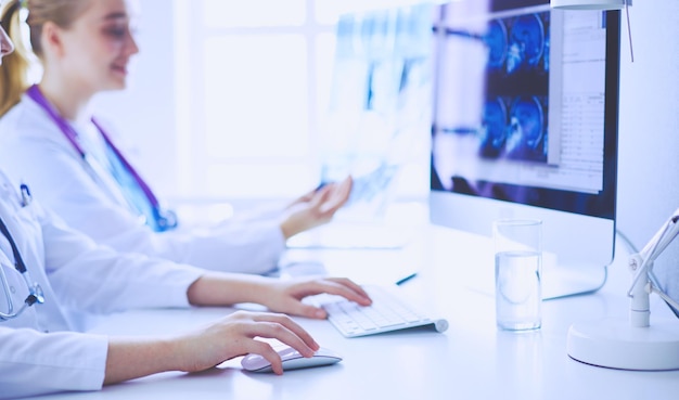 Two young female doctors working on computer at hospital