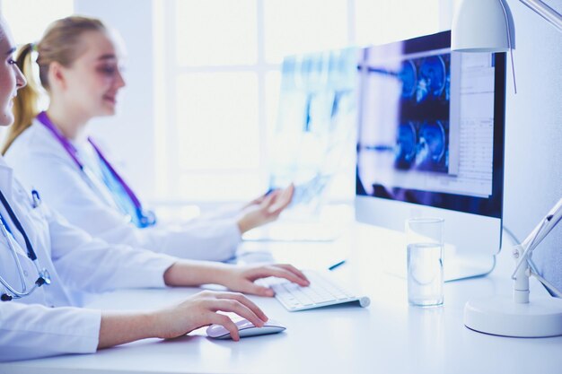 Two young female doctors working on computer at hospital