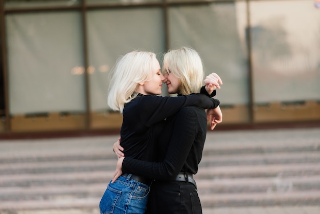 Two young females kissing outdoor in the city