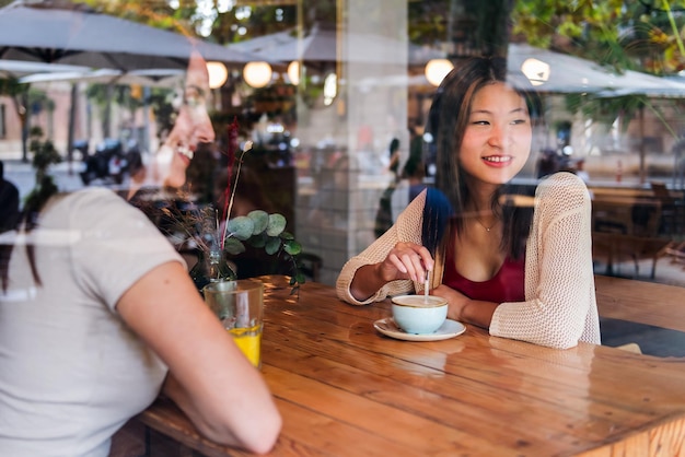 Two young friends enjoying having a cup of coffee