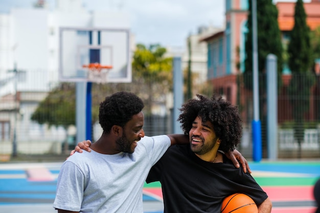 Two young friends having fun playing basketball