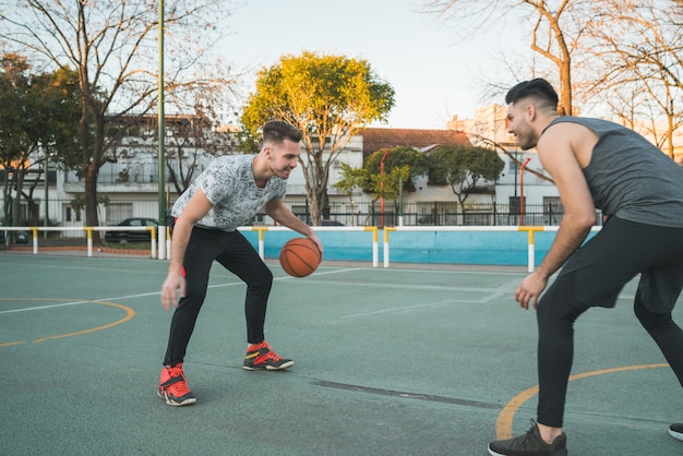 Two young friends playing basketball.