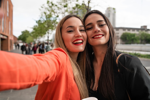 Two young friends taking a selfie outdoors.